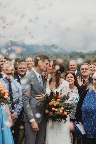 first kiss with wedding party between the urns