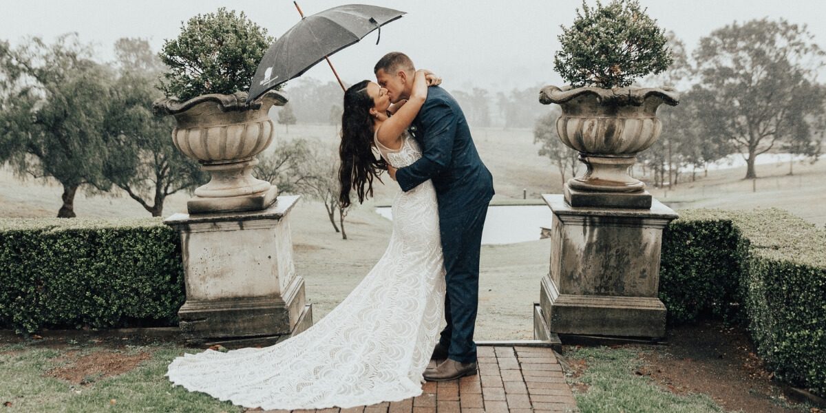 Bride and groom kiss between urns