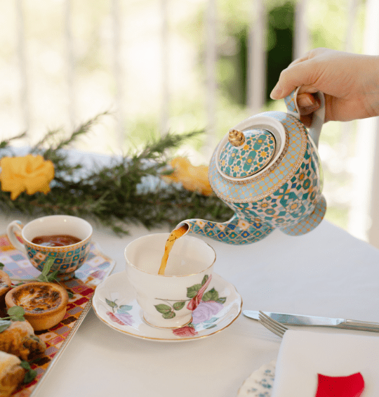 pouring tea into fine china tea cup