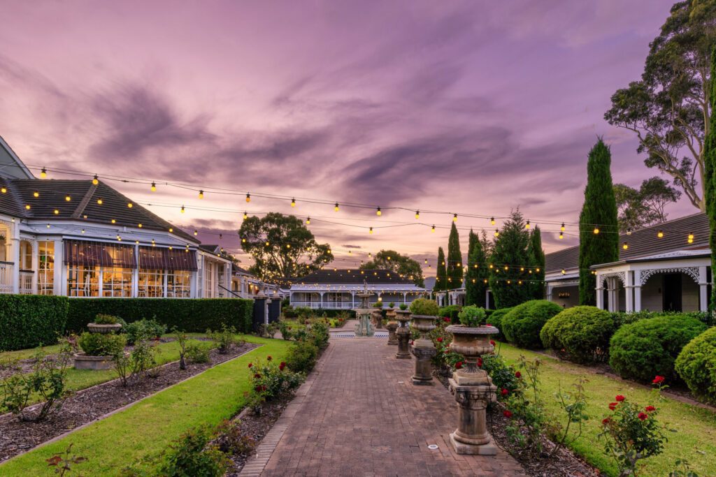 The rose garden and manor at voco Kirkton Park at sunset