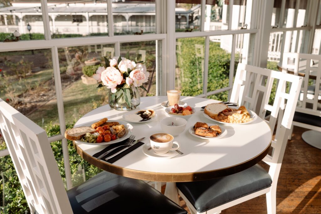 Breakfast served at a table in The Conservatory, looking out to the garden