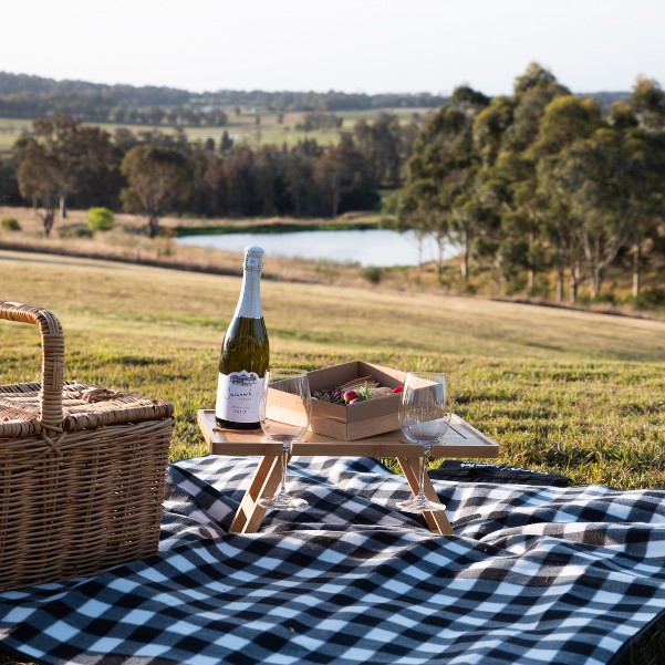 A picnic hamper and sparkling wine on the lawn at voco Kirkton Park