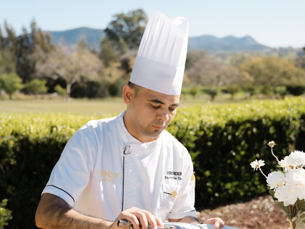 Portfolio Executive Chef Virender Singh plating a dish in the gardens at voco Kirkton Park